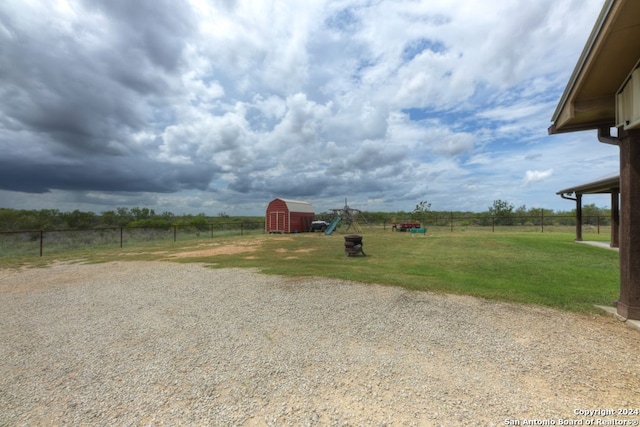 view of yard with a shed and a rural view