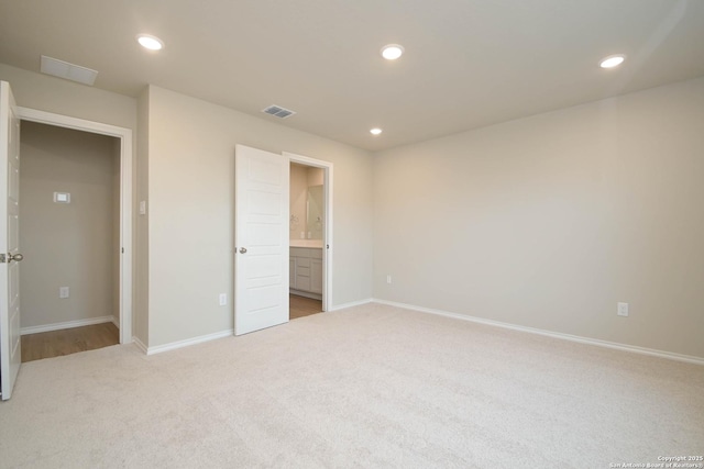 unfurnished bedroom with carpet flooring and ensuite bathroom