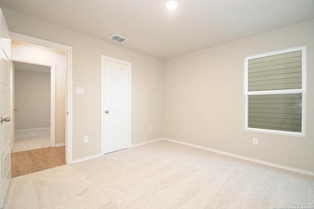 unfurnished bedroom featuring a closet and light carpet