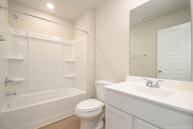 full bathroom featuring vanity, hardwood / wood-style flooring, washtub / shower combination, and toilet