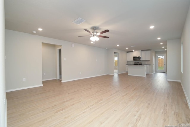 unfurnished living room featuring ceiling fan and light hardwood / wood-style flooring