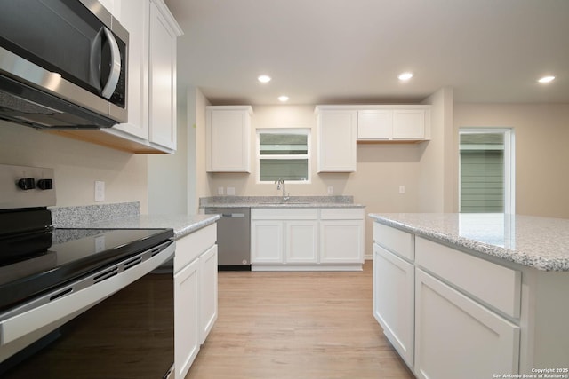 kitchen featuring sink, light wood-type flooring, white cabinetry, and stainless steel appliances