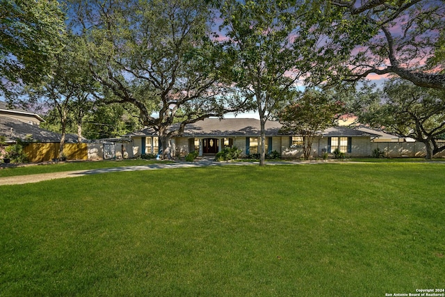 ranch-style home featuring a lawn