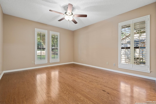 spare room with a textured ceiling, wood-type flooring, and ceiling fan