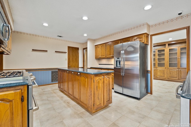 kitchen with tasteful backsplash, appliances with stainless steel finishes, and a center island