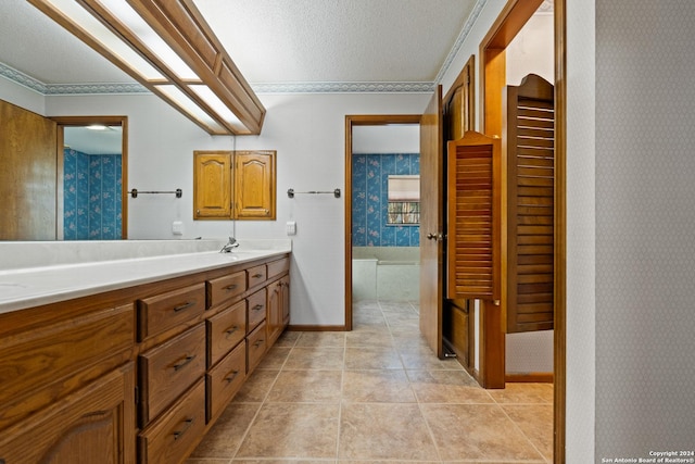 bathroom with tile patterned floors, vanity, and a textured ceiling