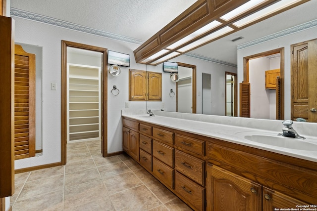 bathroom featuring vanity, tile patterned floors, and a textured ceiling