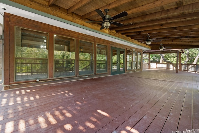 unfurnished sunroom with beamed ceiling, ceiling fan, and wood ceiling