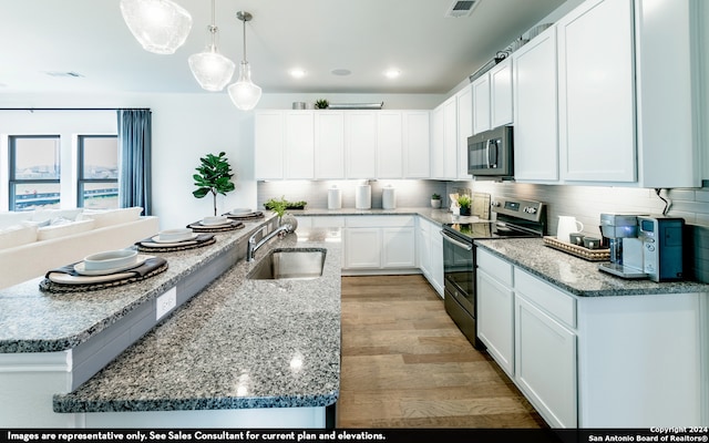 kitchen featuring stainless steel appliances, white cabinets, light wood-type flooring, sink, and backsplash