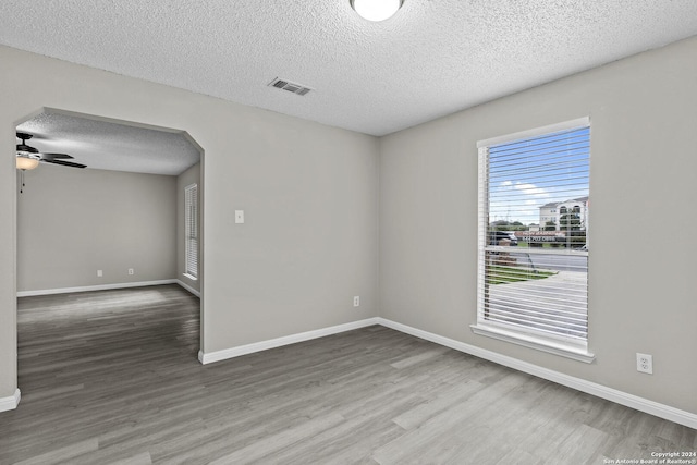 unfurnished room featuring visible vents, ceiling fan, baseboards, and wood finished floors