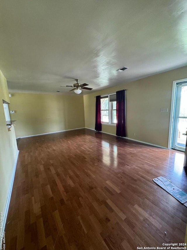 spare room featuring dark wood-type flooring and ceiling fan