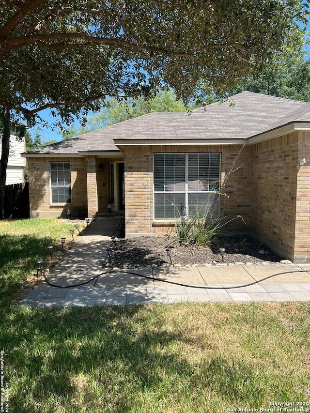 ranch-style house featuring a patio and a front lawn