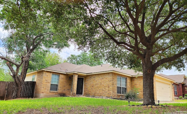 ranch-style home featuring a garage and a front lawn