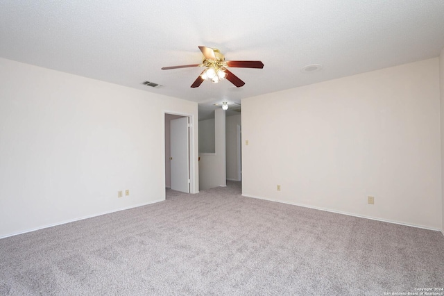 carpeted spare room with ceiling fan and a textured ceiling