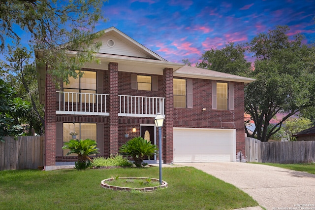 view of front facade with a balcony, a garage, and a yard