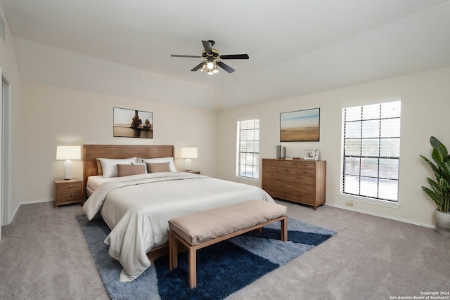 bedroom with ceiling fan, light colored carpet, and multiple windows