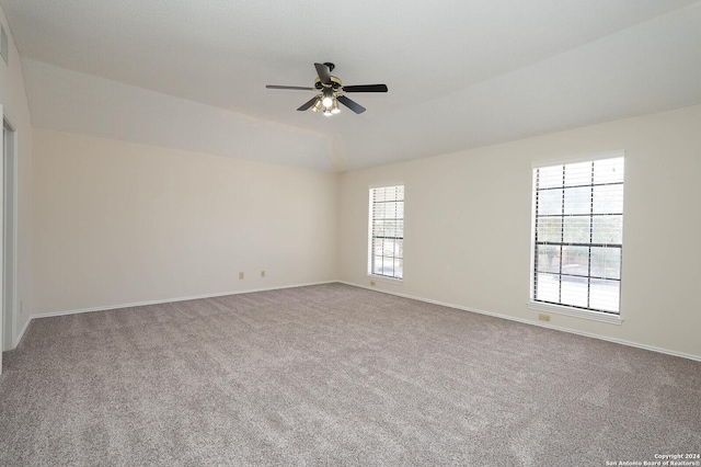 carpeted spare room featuring ceiling fan, plenty of natural light, and vaulted ceiling