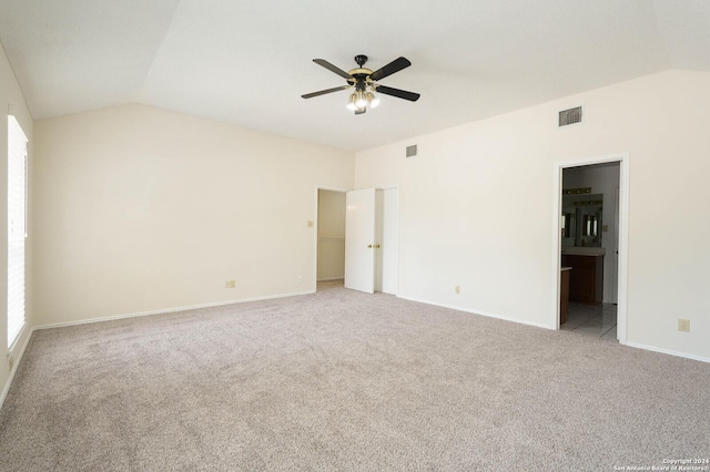 carpeted spare room featuring ceiling fan and vaulted ceiling