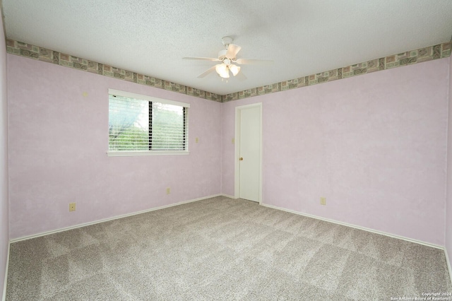 carpeted empty room with ceiling fan and a textured ceiling