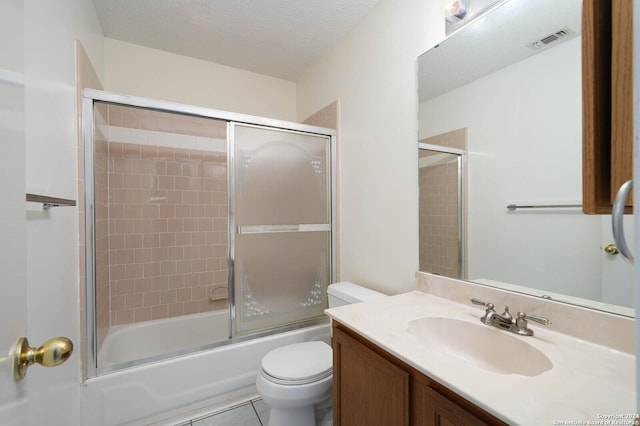 full bathroom with shower / bath combination with glass door, tile patterned flooring, vanity, toilet, and a textured ceiling