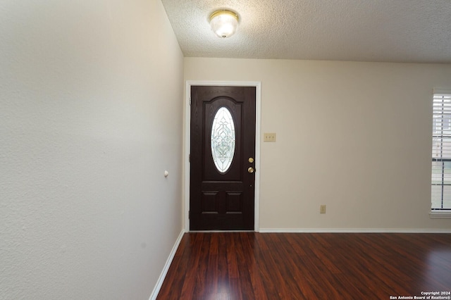 entryway featuring dark wood-type flooring and a textured ceiling