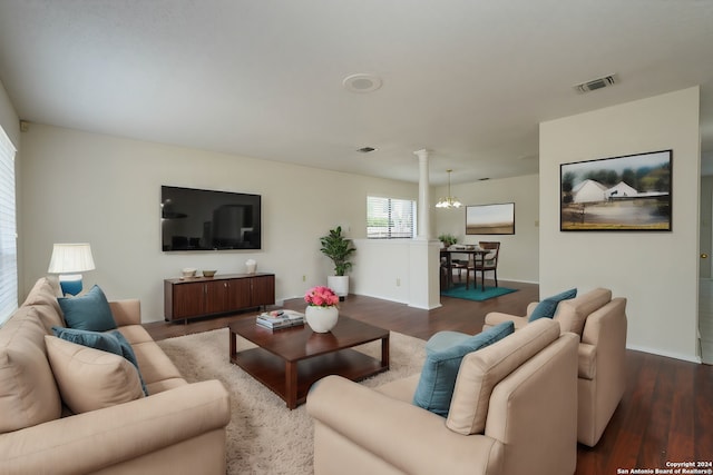 living room with a notable chandelier and dark wood-type flooring