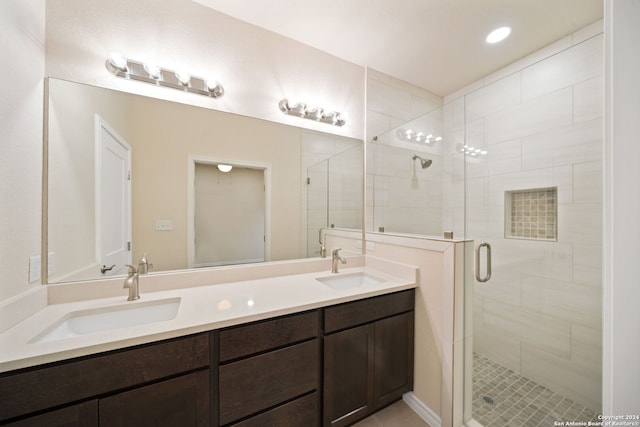 bathroom with double vanity, a stall shower, and a sink