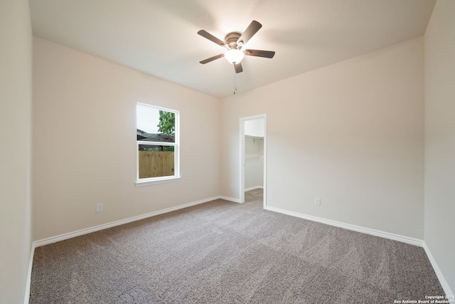 carpeted empty room with a ceiling fan and baseboards