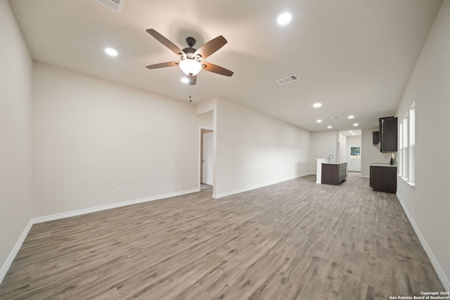 unfurnished living room with recessed lighting, visible vents, light wood finished floors, and baseboards