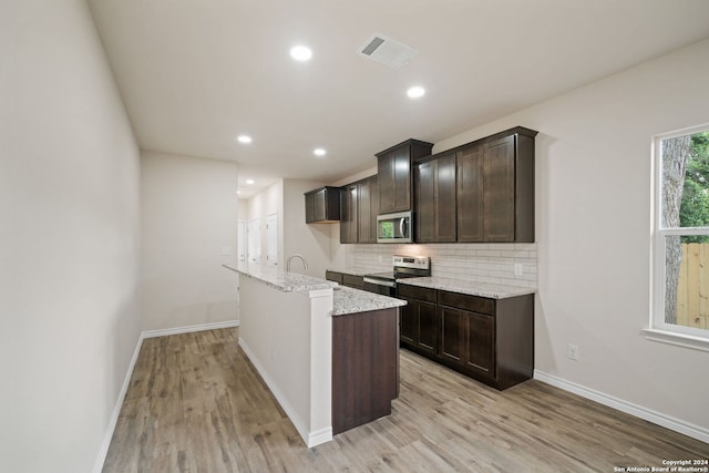 kitchen featuring visible vents, backsplash, appliances with stainless steel finishes, and light wood-style floors