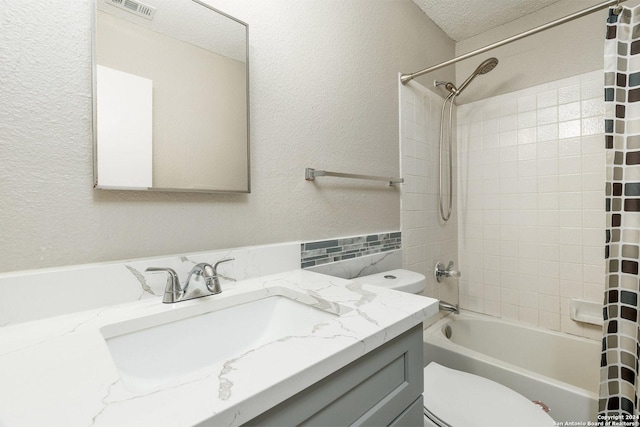 bathroom featuring toilet, visible vents, a textured ceiling, and vanity