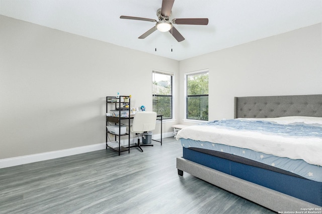 bedroom featuring ceiling fan, baseboards, and wood finished floors