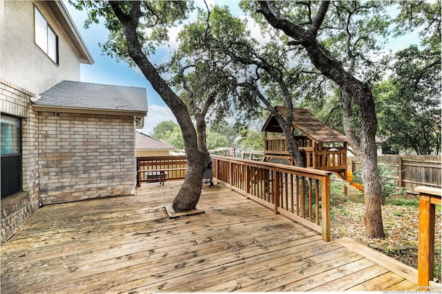 wooden deck with fence and a playground