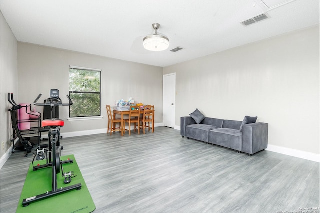 living area featuring baseboards, visible vents, and wood finished floors