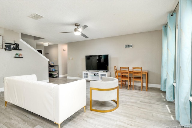 living area with visible vents, ceiling fan, and light wood-style flooring