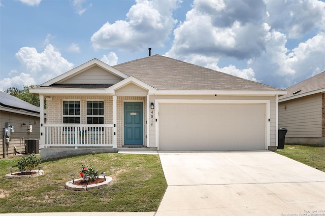 view of front of property with cooling unit, a garage, and a front lawn