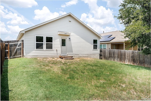 back of property featuring a lawn