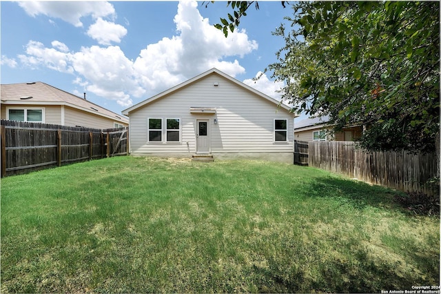 rear view of property with a yard