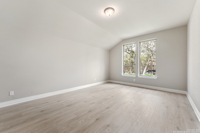 bonus room with lofted ceiling and light wood-type flooring