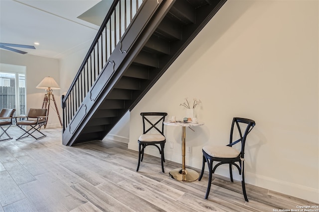 staircase with wood-type flooring and ceiling fan