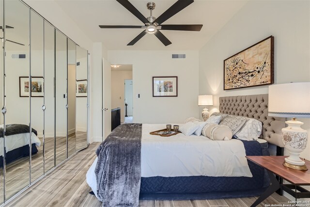 bedroom with light hardwood / wood-style floors, a closet, and ceiling fan