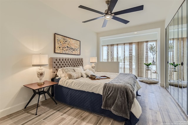 bedroom with access to outside, light hardwood / wood-style floors, and ceiling fan