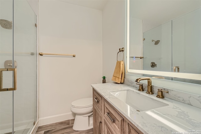 bathroom with vanity, a shower with shower door, and toilet