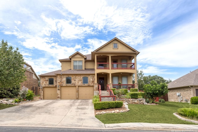 view of front facade featuring a balcony, a garage, and a front yard