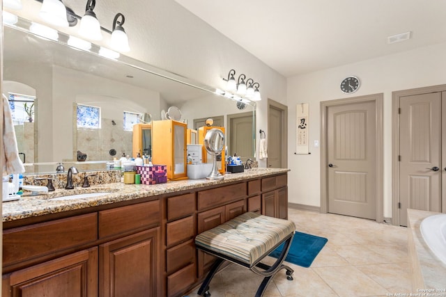 bathroom with tiled tub, tile patterned floors, and double sink vanity