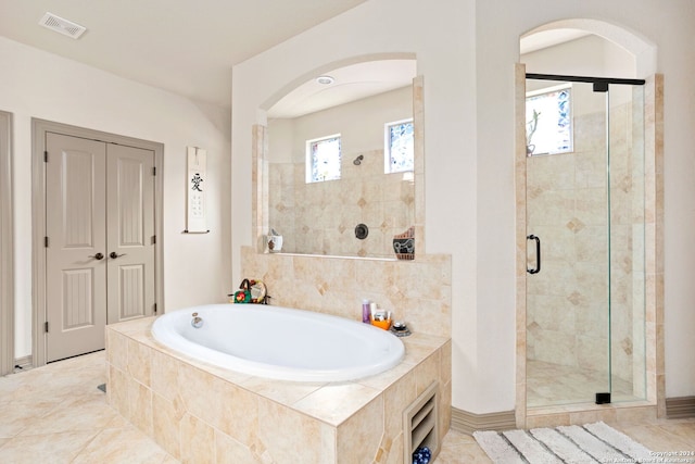 bathroom with independent shower and bath and tile patterned floors