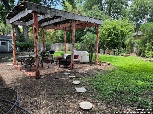 view of yard with a pergola, a patio, and a storage unit