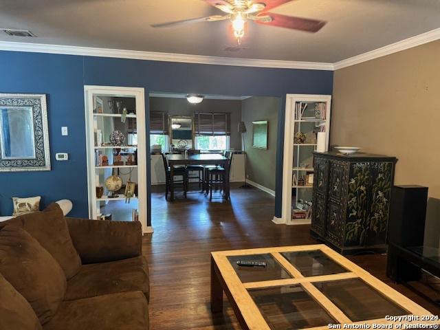 living room with ornamental molding, ceiling fan, and dark hardwood / wood-style flooring