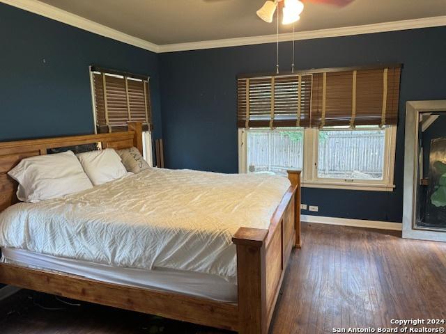 bedroom featuring crown molding and dark hardwood / wood-style floors