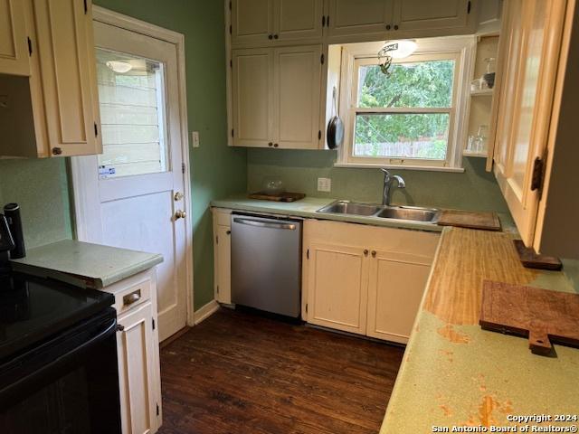 kitchen with dark hardwood / wood-style floors, dishwasher, sink, white cabinets, and black electric range